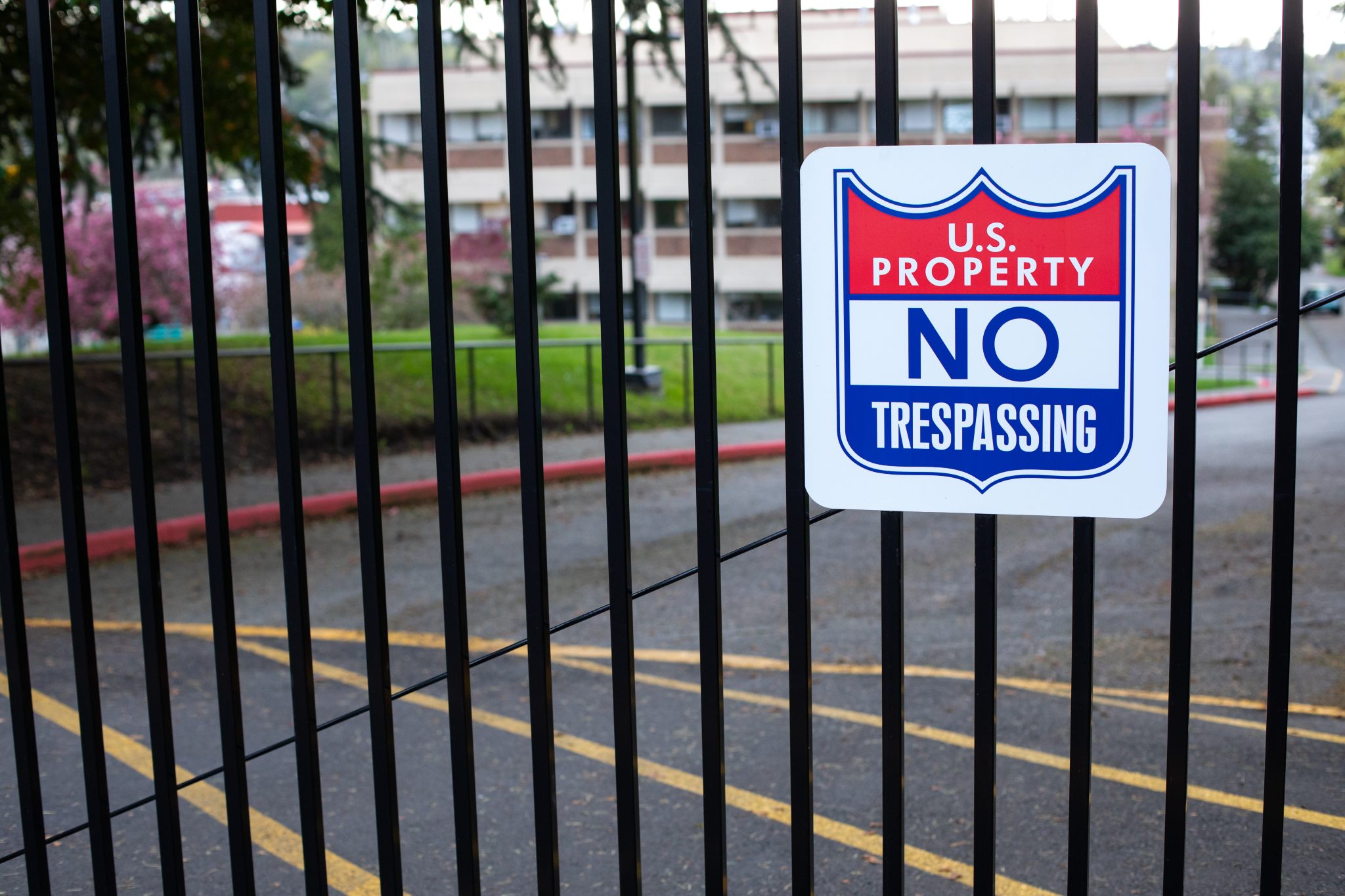 exterior photo of a gate with a U.S. Property no trespassing sign on the gate